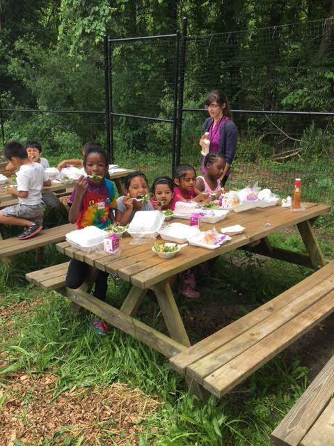 shim children eating at picnic table